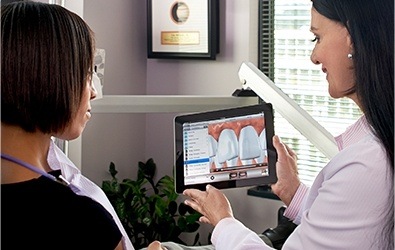 Dr. Tamo looking at smile design with dental patient